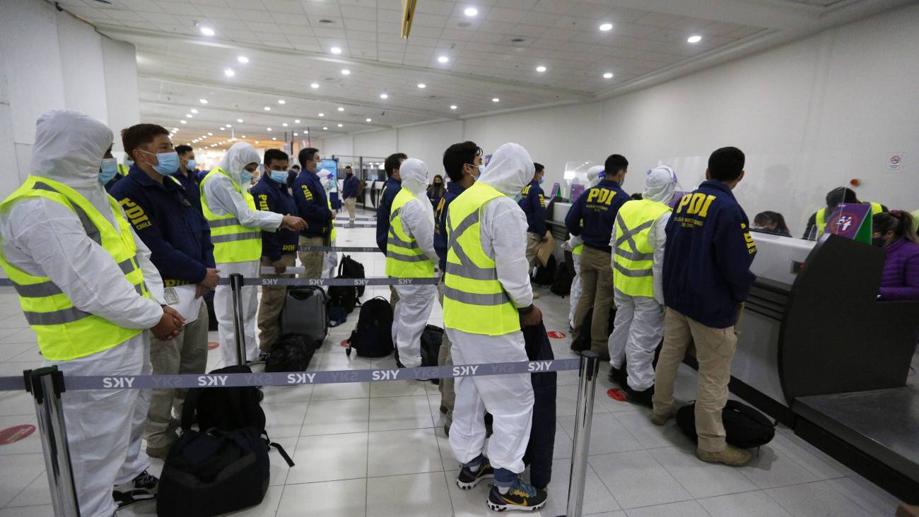 Personas migrantes en el aeropuerto de Santiago luego ser expulsadas de Chile